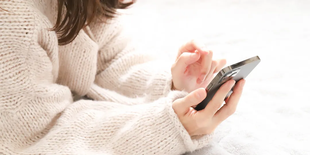 スマホで調べものをしている女性のイメージ